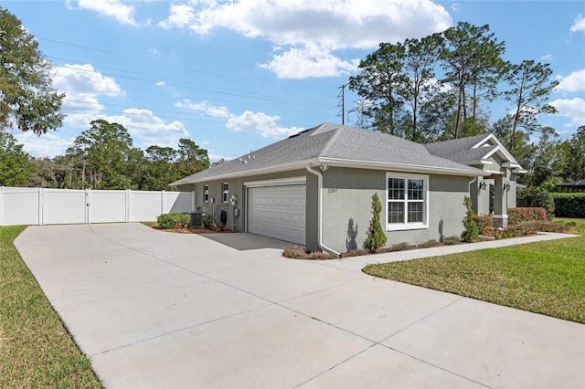 view of side of home with stucco siding, a lawn, a gate, concrete driveway, and a garage