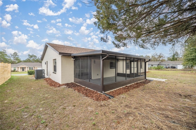 back of property featuring central AC, a sunroom, and a lawn