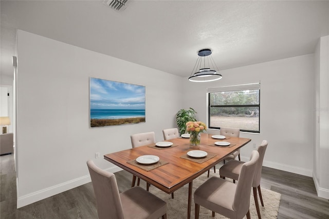 dining area featuring dark hardwood / wood-style flooring and a textured ceiling