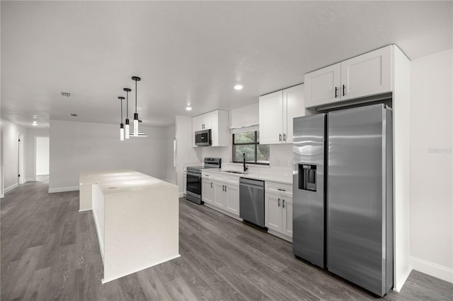 kitchen featuring sink, light hardwood / wood-style flooring, white cabinetry, stainless steel appliances, and decorative light fixtures