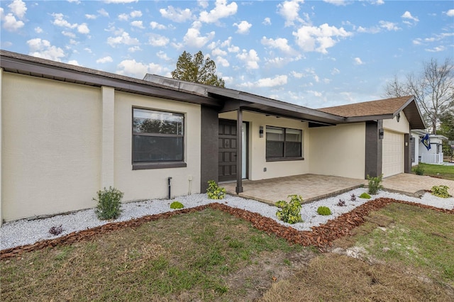 single story home with a garage and a front lawn