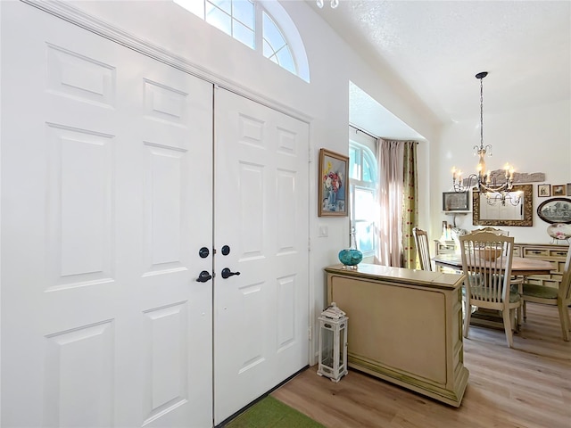 foyer entrance featuring a chandelier and light hardwood / wood-style floors