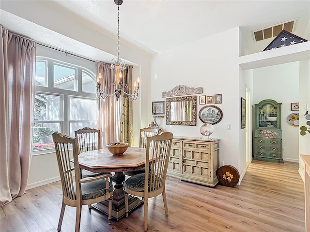 dining room with hardwood / wood-style floors and a chandelier