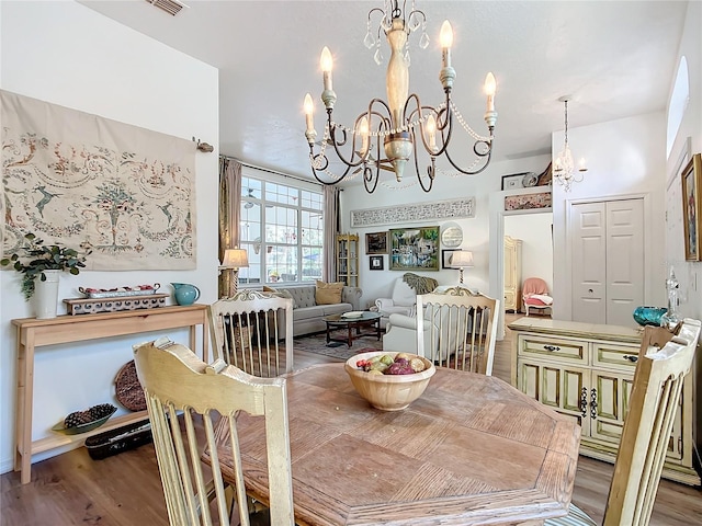 dining area featuring hardwood / wood-style flooring and a chandelier