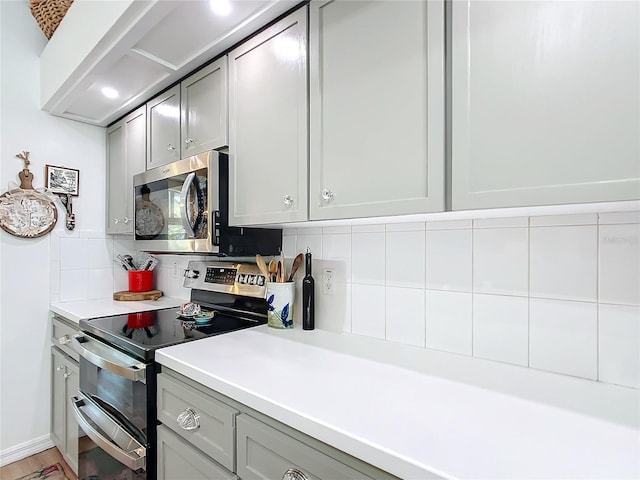 kitchen featuring tasteful backsplash, appliances with stainless steel finishes, and gray cabinets