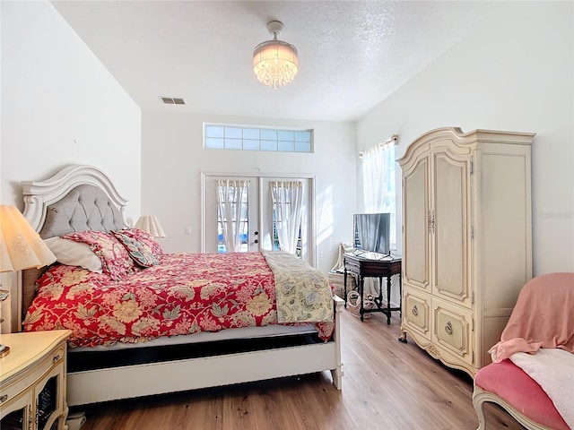 bedroom featuring french doors, access to exterior, and light hardwood / wood-style floors