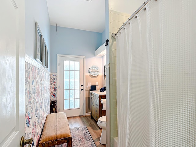 bathroom with hardwood / wood-style flooring, vanity, walk in shower, and toilet