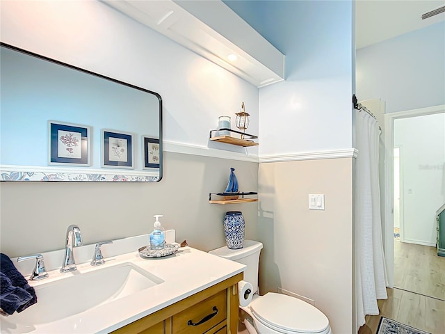 bathroom with hardwood / wood-style flooring, vanity, toilet, and a shower with curtain