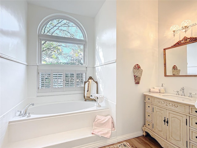 bathroom with vanity, hardwood / wood-style floors, and a tub