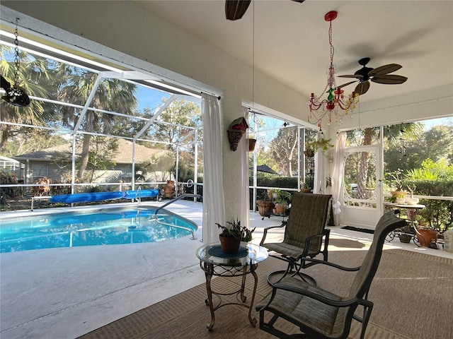 view of swimming pool with a patio, ceiling fan, and glass enclosure