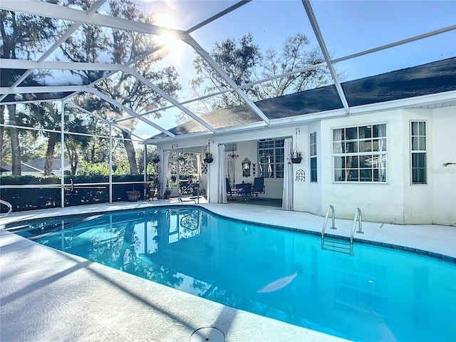 view of pool with a patio area and glass enclosure