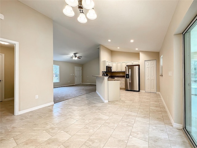 kitchen with ceiling fan with notable chandelier, lofted ceiling, white cabinets, stainless steel appliances, and light stone countertops