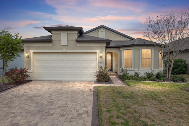 view of front of home featuring a garage and a lawn