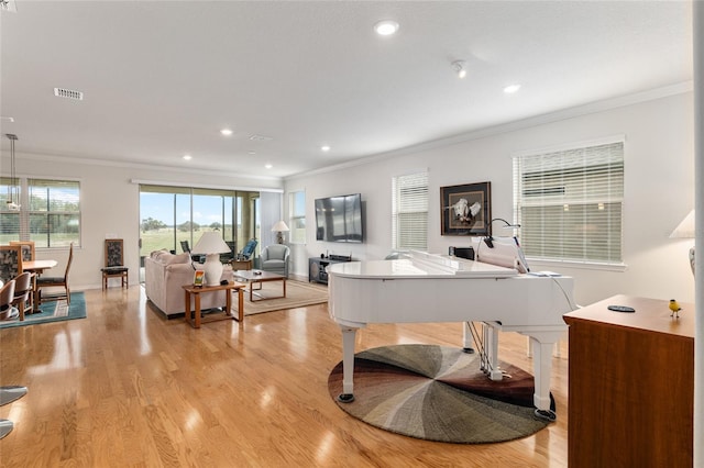 living room with ornamental molding and light hardwood / wood-style flooring