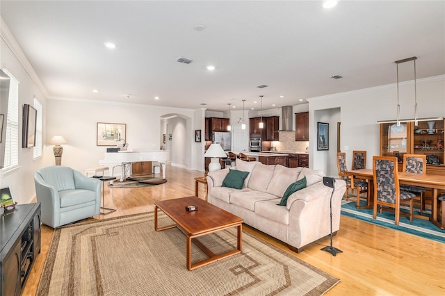 living room featuring ornamental molding and light wood-type flooring