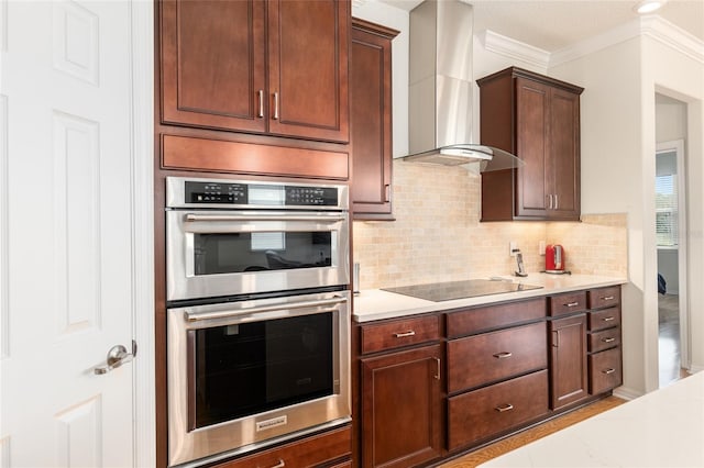 kitchen featuring double oven, tasteful backsplash, ornamental molding, wall chimney range hood, and black electric cooktop