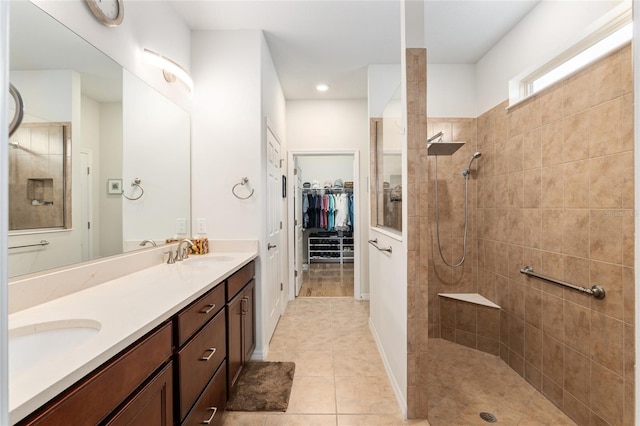 bathroom featuring vanity, tile patterned floors, and tiled shower