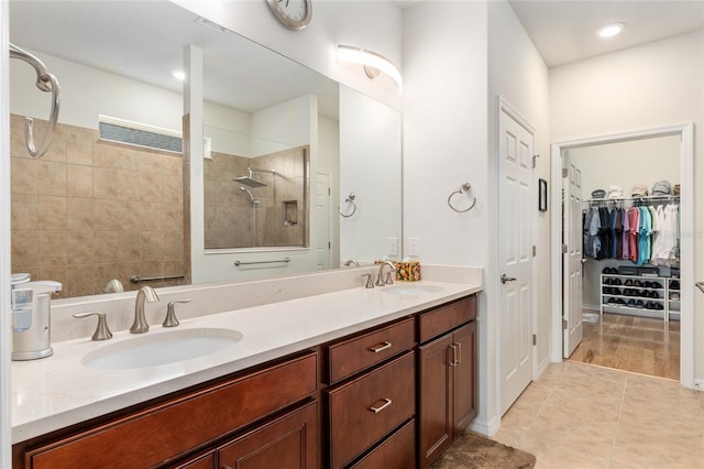 bathroom with vanity, tiled shower, and tile patterned floors