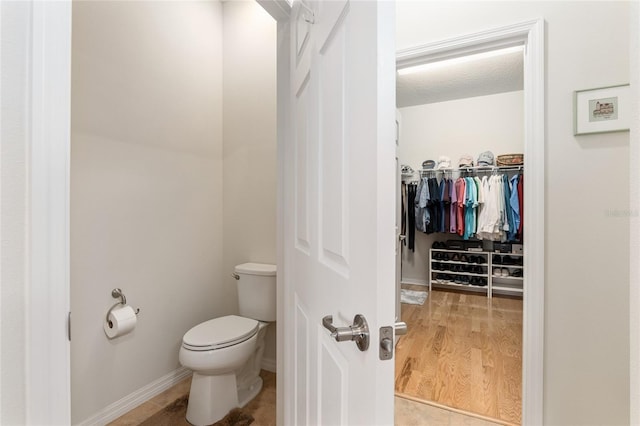 bathroom with hardwood / wood-style flooring and toilet