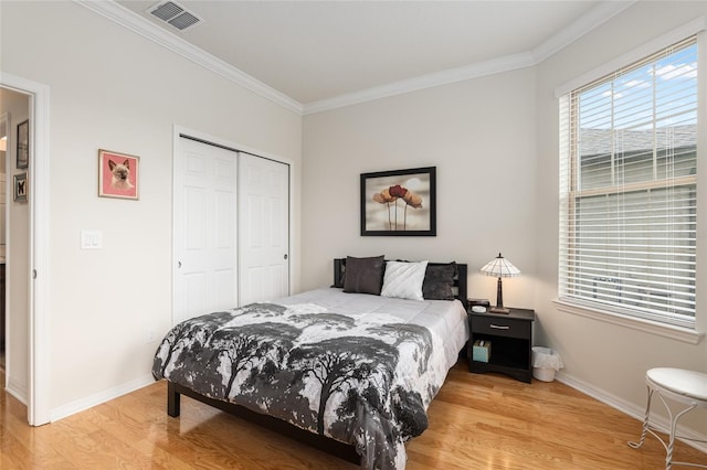 bedroom with crown molding, hardwood / wood-style flooring, and a closet