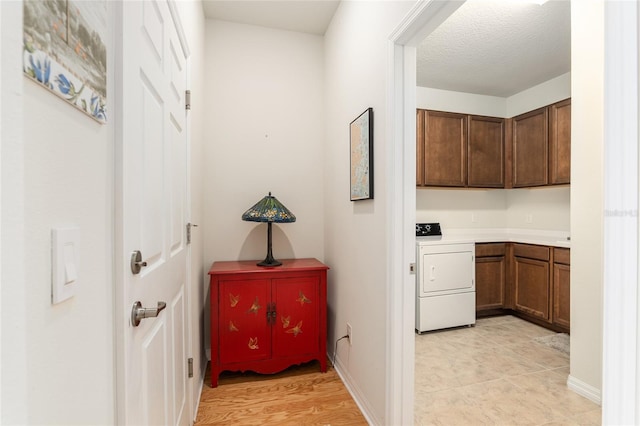 hall with washer / dryer and a textured ceiling