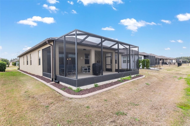 rear view of property with a yard and glass enclosure