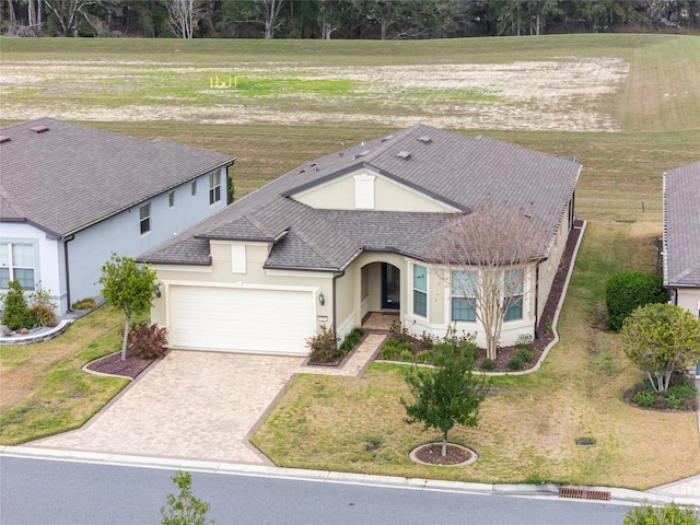 view of front of property with a rural view, a garage, and a front yard