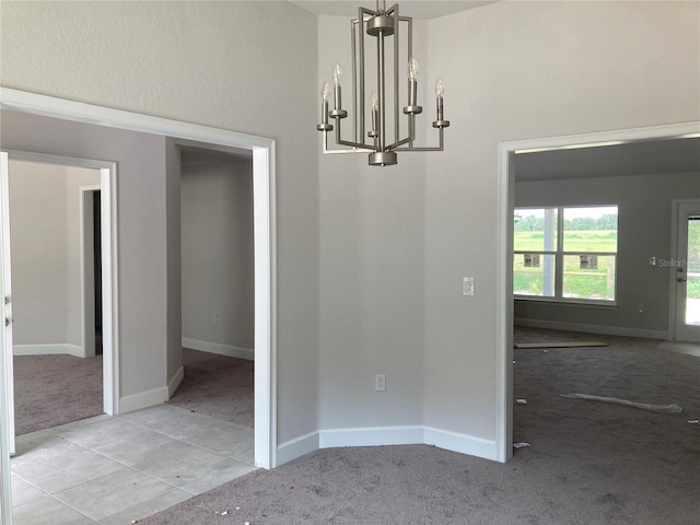 unfurnished dining area with an inviting chandelier and light carpet