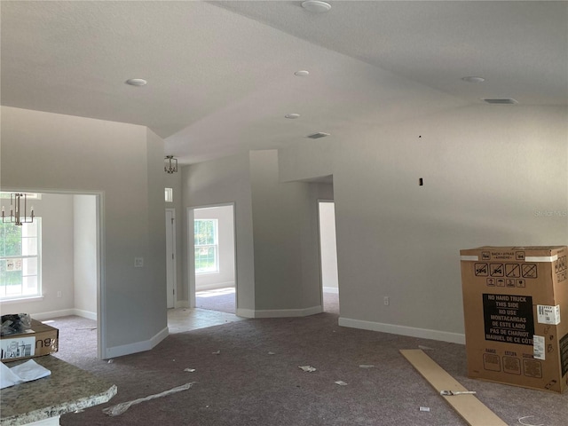 carpeted empty room with lofted ceiling and a wealth of natural light