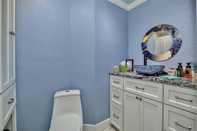 half bath featuring toilet, vanity, crown molding, and a textured wall