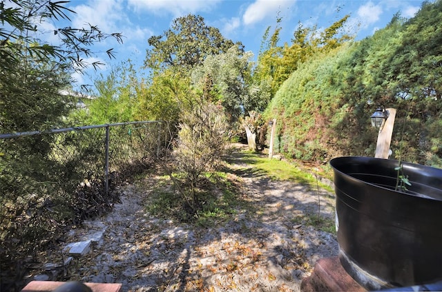 view of yard featuring fence and a wooded view
