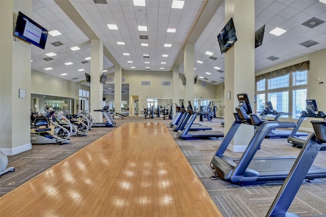 workout area with carpet floors, a towering ceiling, and baseboards