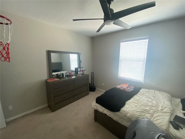 bedroom with light colored carpet, ceiling fan, a textured ceiling, and baseboards