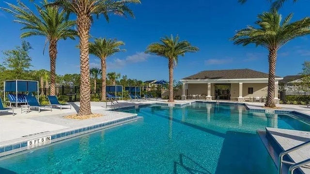 community pool featuring fence and a patio