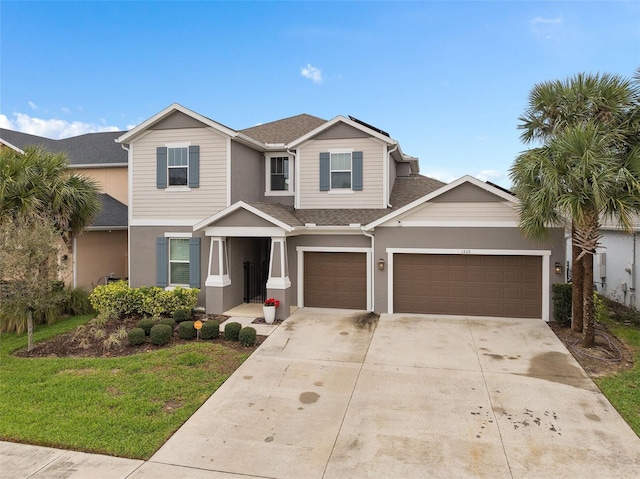 view of front of property with driveway, stucco siding, and roof with shingles