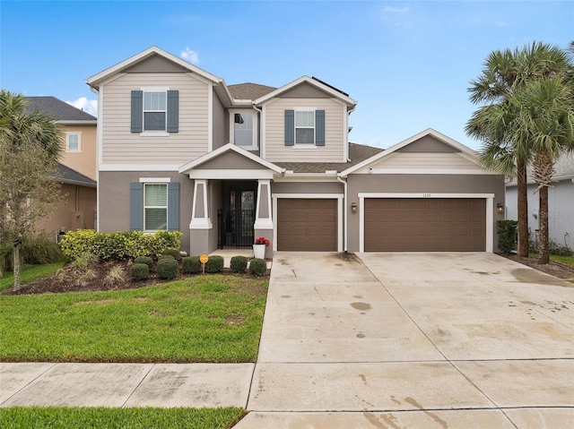 craftsman-style home with a garage, driveway, a front lawn, and stucco siding