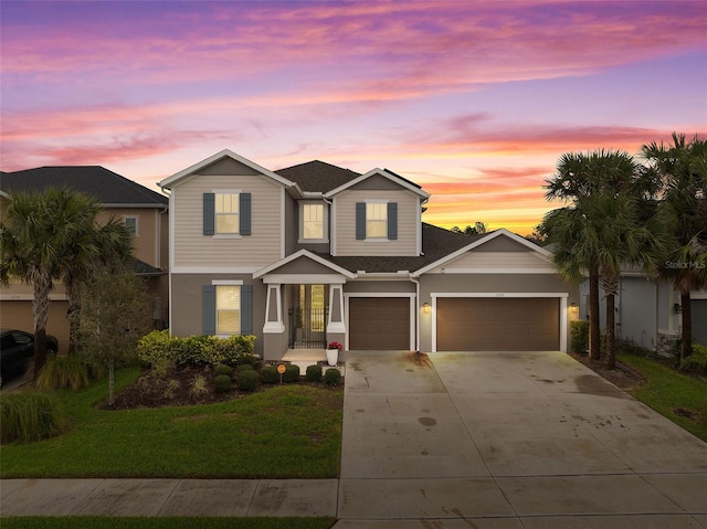 traditional-style house with driveway, an attached garage, and a front yard