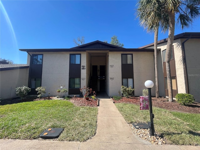 view of front of property with a front yard and stucco siding