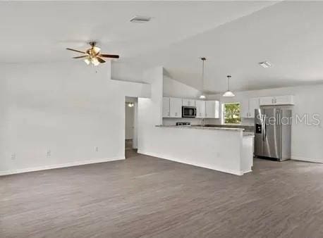 kitchen with dark hardwood / wood-style floors, decorative light fixtures, lofted ceiling, white cabinets, and stainless steel appliances