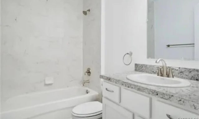 full bathroom featuring tiled shower / bath combo, vanity, and toilet