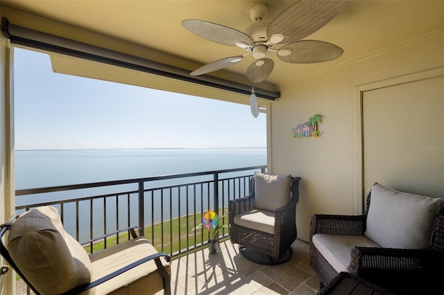 balcony with a water view and a ceiling fan