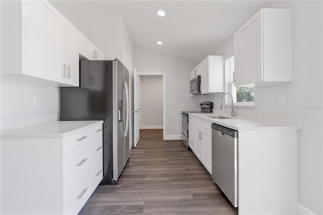 kitchen with vaulted ceiling, white cabinetry, sink, light hardwood / wood-style floors, and stainless steel appliances