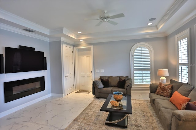 living room with ceiling fan, ornamental molding, and a tray ceiling