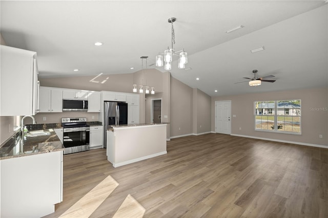 kitchen featuring white cabinetry, a center island, hanging light fixtures, stainless steel appliances, and light hardwood / wood-style floors