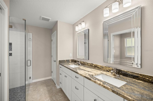 bathroom with vanity, a textured ceiling, and walk in shower