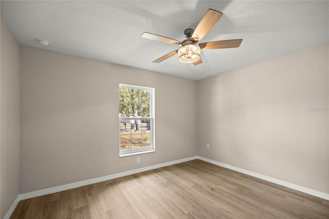 empty room featuring a textured ceiling, ceiling fan, and light wood-type flooring