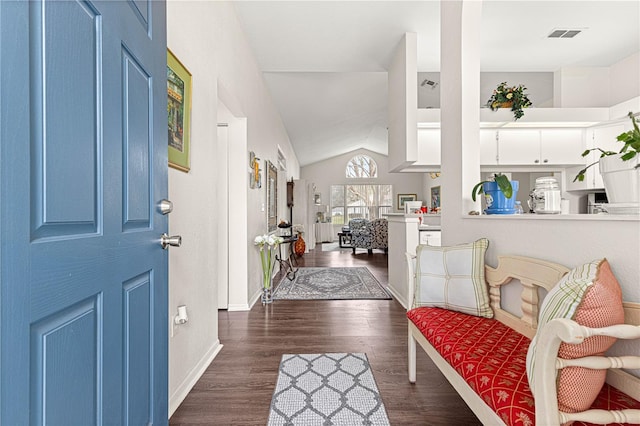 entryway featuring dark wood-style floors, lofted ceiling, visible vents, and baseboards