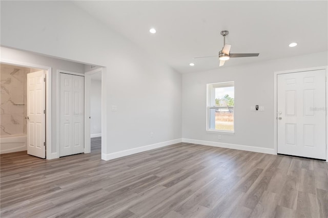 interior space featuring ensuite bathroom, vaulted ceiling, light hardwood / wood-style flooring, ceiling fan, and a closet