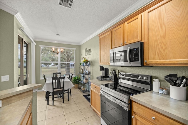 kitchen featuring decorative light fixtures, light tile patterned floors, stainless steel appliances, crown molding, and an inviting chandelier