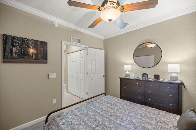 bedroom featuring ornamental molding, light carpet, ceiling fan, and a closet
